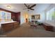 Carpeted primary bedroom with plantation shutters, a sitting area, and ample closet space for storage at 19334 W Pasadena Ave, Litchfield Park, AZ 85340