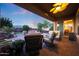 Inviting covered patio with comfortable seating, ceiling fan and a view of the backyard fire pit at 19334 W Pasadena Ave, Litchfield Park, AZ 85340