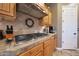 Kitchen detail showcasing a gas cooktop, tile backsplash, and wooden cabinetry at 19334 W Pasadena Ave, Litchfield Park, AZ 85340