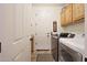 Bright laundry room with tile floors, cabinetry, and modern washer and dryer at 19334 W Pasadena Ave, Litchfield Park, AZ 85340