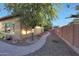 Charming side yard with a stone pathway, mature tree, desert landscaping, and privacy fence at 19334 W Pasadena Ave, Litchfield Park, AZ 85340