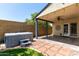 Relaxing backyard featuring a covered patio, hot tub, and meticulously laid stone and brick pathway at 19833 N 47Th Ln, Glendale, AZ 85308