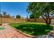 Lush backyard featuring a vibrant green lawn, desert landscaping, and mature shade trees at 19833 N 47Th Ln, Glendale, AZ 85308