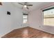 Bright bedroom with wood-look floors, a window with blinds and a modern ceiling fan at 19833 N 47Th Ln, Glendale, AZ 85308