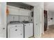 Laundry room with modern white washer and dryer, with white storage shelving above at 19833 N 47Th Ln, Glendale, AZ 85308
