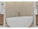 Bright bathroom featuring a modern soaking tub with gold fixtures and decorative accent wall at 2 Biltmore Est # 313, Phoenix, AZ 85016