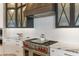 Gourmet kitchen with stainless steel range, hood, custom cabinetry, and white backsplash at 2 Biltmore Est # 313, Phoenix, AZ 85016