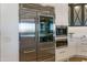 Modern kitchen featuring stainless steel refrigerator and cabinets with herringbone patterned glass at 2 Biltmore Est # 313, Phoenix, AZ 85016