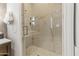 Bright marble tiled shower with glass doors, built in shelves, and modern fixtures at 2 Biltmore Est # 313, Phoenix, AZ 85016