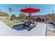 Lush backyard with artificial turf, built-in bbq, and a red picnic table with umbrella at 2033 E Hillery Dr, Phoenix, AZ 85022