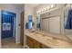 Well-lit bathroom features a double sink vanity, and walk-in shower with neutral tiling at 2033 E Hillery Dr, Phoenix, AZ 85022