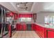 Vibrant kitchen features bold red cabinets, modern appliances, and tile flooring at 2033 E Hillery Dr, Phoenix, AZ 85022