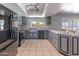 Well-lit kitchen with skylight and a window overlooking backyard, with black appliances and stylish gray cabinets at 2033 E Hillery Dr, Phoenix, AZ 85022