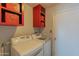 Functional laundry room equipped with washer, dryer, and red storage cabinets at 2033 E Hillery Dr, Phoenix, AZ 85022