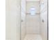 Tiled shower with glass door, decorative tile details, and a small window at 20704 N 90Th Pl # 1015, Scottsdale, AZ 85255