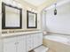 Bright bathroom featuring a double vanity, mirrors, and soaking tub with decorative tile accents at 20704 N 90Th Pl # 1015, Scottsdale, AZ 85255