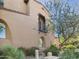 Exterior of a tan stucco home with a small balcony and desert landscaping at 20704 N 90Th Pl # 1015, Scottsdale, AZ 85255