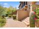 Two story home with manicured desert landscaping, steps to entry, and unique cactus features, all under a bright blue sky at 20704 N 90Th Pl # 1015, Scottsdale, AZ 85255
