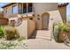Inviting front entrance with a charming arched doorway, desert landscaping, and a private balcony above at 20704 N 90Th Pl # 1015, Scottsdale, AZ 85255