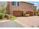 Two-car garage with brown doors, desert landscaping, and a brick-paved driveway, combining functionality and curb appeal at 20704 N 90Th Pl # 1015, Scottsdale, AZ 85255