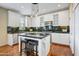 Bright kitchen featuring white cabinetry, modern appliances, granite countertops, and an island with bar seating at 20704 N 90Th Pl # 1015, Scottsdale, AZ 85255