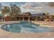 Community pool with umbrellas and pergola covered seating area with stone fireplace at 20704 N 90Th Pl # 1015, Scottsdale, AZ 85255