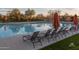 Community pool with lounge chairs and orange umbrellas for shade at 20704 N 90Th Pl # 1015, Scottsdale, AZ 85255