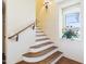 Elegant staircase with wood treads and white risers complemented by a window with flower box, filling the space with light at 20704 N 90Th Pl # 1015, Scottsdale, AZ 85255
