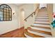 Inviting staircase features wood treads and a wooden handrail, with natural light from a window and classic wall sconces at 20704 N 90Th Pl # 1015, Scottsdale, AZ 85255