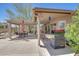 A spacious covered backyard patio includes an outdoor grill, seating area and desert landscaping at 20739 N 106Th Ln, Peoria, AZ 85382