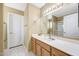 Well-lit bathroom with a large mirror, vanity, and a door to a shower at 20739 N 106Th Ln, Peoria, AZ 85382