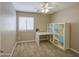 Neutrally decorated bedroom featuring a window, ceiling fan, and a shelving unit with storage at 22333 E Calle De Flores St, Queen Creek, AZ 85142