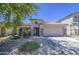 Beautiful single-story home with a two-car garage and front yard featuring gravel landscaping and desert foliage at 22333 E Calle De Flores St, Queen Creek, AZ 85142