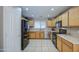 The well-equipped kitchen features stainless steel appliances and beautiful wooden cabinetry at 22333 E Calle De Flores St, Queen Creek, AZ 85142