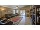 Cozy living room features leather furniture, a ceiling fan, tile flooring, and backyard access at 22333 E Calle De Flores St, Queen Creek, AZ 85142