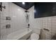 Bathroom with a tub, shower, white tiling, and black fixtures for a modern aesthetic at 228 E Del Rio Dr, Tempe, AZ 85282