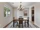 Elegant dining room featuring a modern chandelier, stylish rug, and beautiful wood floors at 22812 N 123Rd Dr, Sun City West, AZ 85375