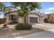 Front exterior features lush landscaping, a spacious driveway, and a welcoming two-car garage at 22812 N 123Rd Dr, Sun City West, AZ 85375