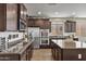 Open kitchen with stainless steel appliances, granite countertops, and dark wood cabinets at 22812 N 123Rd Dr, Sun City West, AZ 85375