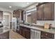 Beautiful kitchen with stainless steel appliances, granite countertops, and dark wood cabinets at 22812 N 123Rd Dr, Sun City West, AZ 85375