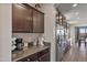 Modern kitchen featuring stainless steel fridge, granite countertops, and dark cabinets at 22812 N 123Rd Dr, Sun City West, AZ 85375