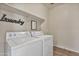 Bright laundry room featuring side-by-side white washer and dryer units with shelving at 22812 N 123Rd Dr, Sun City West, AZ 85375