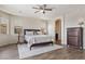 Bright main bedroom showcasing neutral walls, wood-look tile floors, and an arched doorway at 22812 N 123Rd Dr, Sun City West, AZ 85375