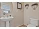Charming powder room with pedestal sink, decorative shelves, and a framed wall art at 22812 N 123Rd Dr, Sun City West, AZ 85375