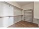 Walk-in closet with built-in shelving and wood-look tile floors at 22812 N 123Rd Dr, Sun City West, AZ 85375