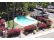 Community pool is surrounded by pink bougainvillea, mature trees and a covered area for shade at 2515 S Maple Ave # 103, Tempe, AZ 85282