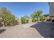 The backyard is a private retreat with gravel landscaping and a mature trees, creating a serene outdoor setting at 2629 E Verbena Dr, Phoenix, AZ 85048