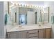 Bright bathroom with double sinks, vanity lighting, and large mirror at 2629 E Verbena Dr, Phoenix, AZ 85048