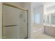 Bright bathroom featuring a built-in tub and glass-enclosed shower at 2629 E Verbena Dr, Phoenix, AZ 85048