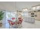 Open dining area featuring a glass-top table, four chairs, sliding glass door, and adjacent kitchen at 2629 E Verbena Dr, Phoenix, AZ 85048